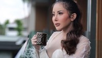 Pada jeda waktu bekerjanya, Ayu Aulia memilih beristirahat dengan segelas minuman hangat. Berdiri di balkon sambil menyeruput minumannya menjadi cara Ayu Aulia untuk istirahat sejenak. Foto: Instagram/@ayuaulia5252