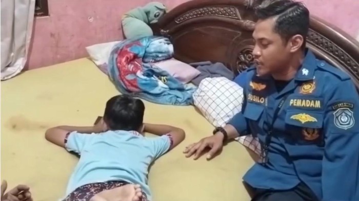 Petugas Damkar Lamongan saat berusaha membujuk dan berbicara dengan anak tantrum usai mengubrak-abrik rumah