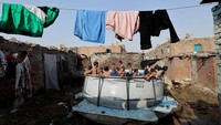 Sekelompok anak berenang di kolam portabel di Manshiyet Nasser, mengubah hari panas menjadi momen penuh canda tawa. Foto: REUTERS/Mohamed Abd El Ghany