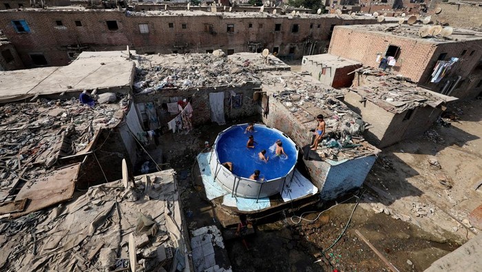 Children play in a portable swimming pool, offering respite from the summer heat for residents who are unable to afford travelling to the beaches along the Mediterranean Sea to cool off, during a heat wave, in Manshiyet Nasser shanty town, Al-Duwayqa, in Cairo, Egypt, August 11, 2025. REUTERS/Mohamed Abd El Ghany