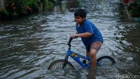Banjir juga dimanfaatkan anak-anak untuk bermain air.