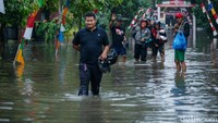 Warga berjalan menerobos banjir.