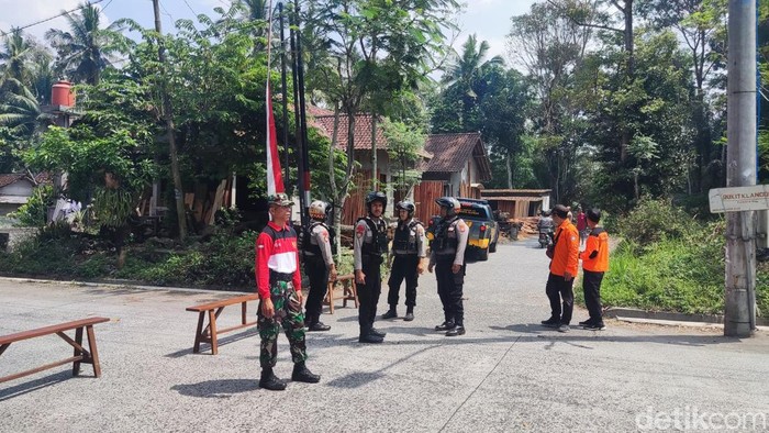 Petugas berjaga di akses menuju lokasi disposal bom mortir 1 meter di Glagaharjo, Sleman, Selasa (12/8/2025)., Sleman,