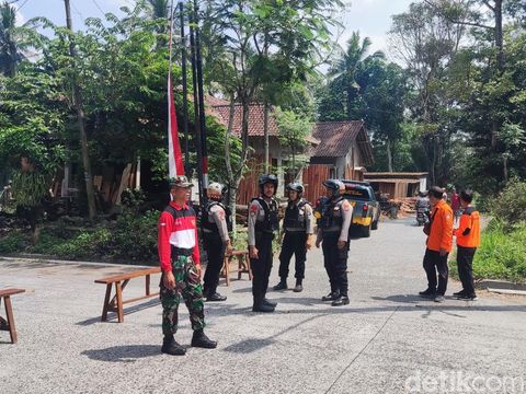 Petugas berjaga di akses menuju lokasi disposal bom mortir 1 meter di Glagaharjo, Sleman, Selasa (12/8/2025)., Sleman,
