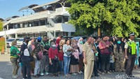Warga yang telah mendaftar dan mendapat kupon tampak antre mengambil bendera dan sembako.