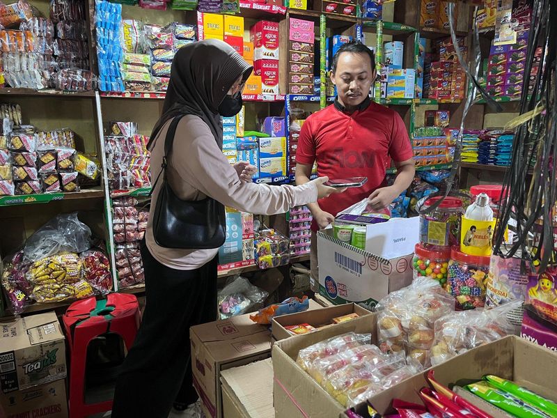 Seorang pembeli bertransaksi menggunakan QRIS di salah satu pasar tradisional di Jakarta.