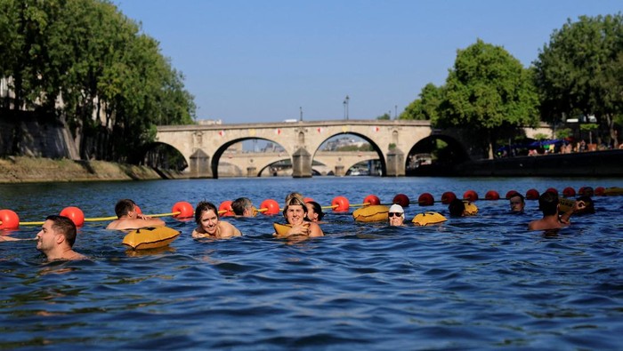 People swim in the River Seine at the Bras Marie site on a sunny and warm summer day as a heatwave hits France, in Paris, France, August 12, 2025. REUTERS/Stephanie Lecocq