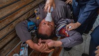 Personel polisi terluka dalam aksi mendapat pertolongan dari tim kesehatan. Foto: ANTARA FOTO/Aji Styawan