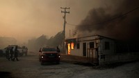 Cuaca panas dan angin kencang memperburuk kondisi, membuat api sulit dikendalikan. REUTERS/Louiza Vradi