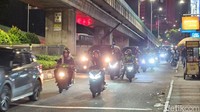 Sejumlah pengendara motor yang melintas mencoba menghindari lubang. Lubang tersebut berada persis di tengah jalan.