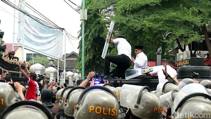 Bupati Pati Sudewo menemui massa aksi di depan kantornya, Rabu (13/8/2025). Tampak ajudannya berupaya pasang badan cegah Sudewo terkena lemparan botol.