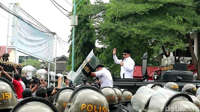 Bupati Pati Sudewo menemui massa aksi di depan kantornya, Rabu (13/8/2025). Tampak ajudannya berupaya pasang badan cegah Sudewo terkena lemparan botol.