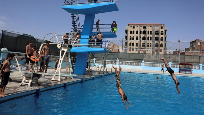 Gelombang Panas Terjang Sanaa, Kolam Renang Diserbu Pengunjung Boys jump into a swimming pool seeking relief from the summer heat, in Sanaa, Yemen, August 7, 2025. REUTERS/Khaled Abdullah