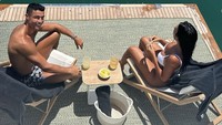 Kembali pamer kemesraan, pasangan ini sedang santai di pinggir laut ditemani camilan dan minuman segar. Lots of love, tulis model Argentina-Spanyol ini. Foto: Instagram georginagio