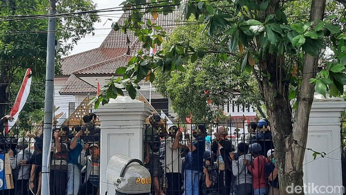 Massa naik pagar DPRD Pati saat demo desak Bupati Sudewo mundur, Rabu (13/8/2025).