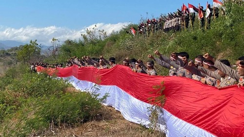 Pembentangan bendera merah putih oleh jajaran Polres Bima, di Bukit Gunung Dorobelo, Desa Belo, Kecamatan Palibelo, Kabupaten Bima, Selasa, (12/8/2025). (Dok. Polres Bima)