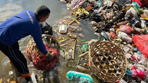 Petugas saat membersihkan sampah di sungai wilayah Denpasar.