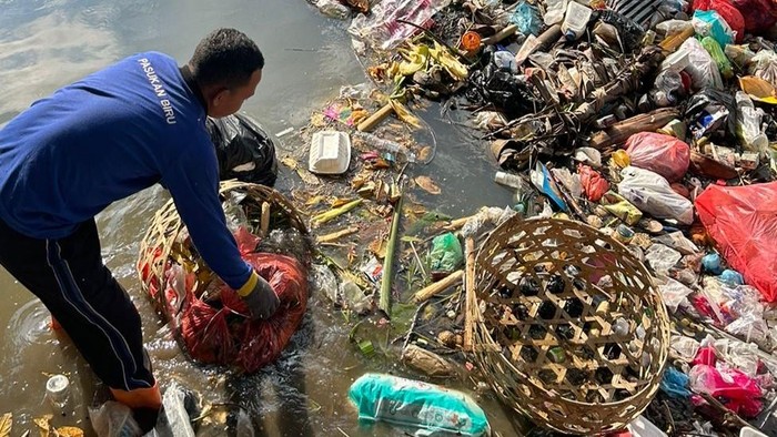 Petugas saat membersihkan sampah di sungai wilayah Denpasar.