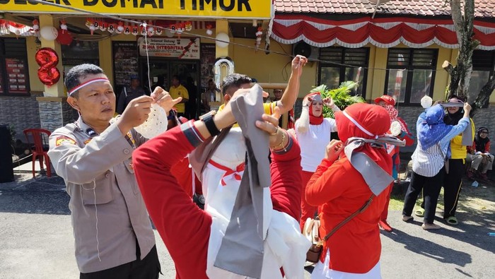 Polisi dan warga di Kota Dumai, Riau, berlomba menyambut Hari Kemerdekaan RI, Rabu (13/8/2025).
