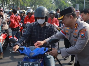 Polrestabes Surabaya Bagikan Ribuan Bendera dan Helm Gratis