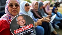 Sejumlah pendukung yang sejak pagi berkumpul di luar gedung pengadilan langsung bereaksi dengan teriakan gembira dan mengibarkan atribut bergambar Najib. Mereka menganggap putusan ini sebagai kemenangan penting bagi mantan perdana menteri yang kini menjalani hukuman penjara terkait kasus skandal keuangan. REUTERS/Hasnoor Hussain