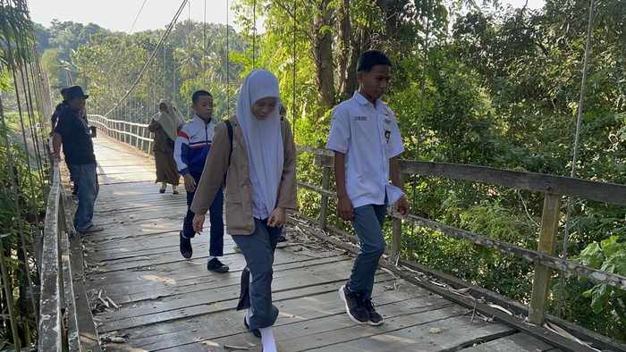 Siswa melintas di jembatan yang mulai rapuh dan nyaris putus di Enrekang.