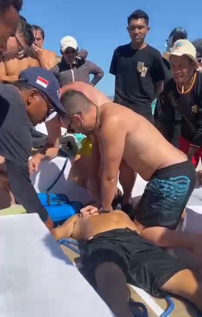 Wisatawan mancanegara melakukan resusitasi jantung paru (RJP) terhadap tour guide bernama Alexander Hibur yang dikabarkan tenggelam saat snorkeling. (Istimewa)