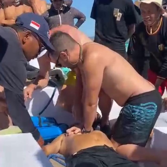 Wisatawan mancanegara melakukan resusitasi jantung paru (RJP) terhadap tour guide bernama Alexander Hibur yang dikabarkan tenggelam saat snorkeling. (Istimewa)