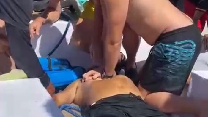 Wisatawan mancanegara melakukan resusitasi jantung paru (RJP) terhadap tour guide bernama Alexander Hibur yang dikabarkan tenggelam saat snorkeling. (Istimewa)