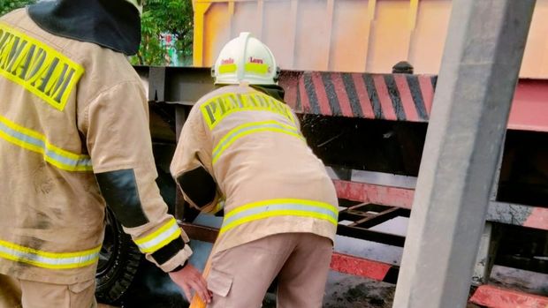 Damkar Jakut memadamkan motor yang terbakar di kolong truk kontainer di Cilincing.