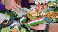 Peserta membagikan makanan yang diolah dari bahan pangan lokal kepada warga saat Festival Pangan dan Cipta Menu Bergizi di Desa Sumerta Kelod, Denpasar, Bali, Kamis (14/8/2025).  ANTARA FOTO/NYOMAN HENDRA WIBOWO