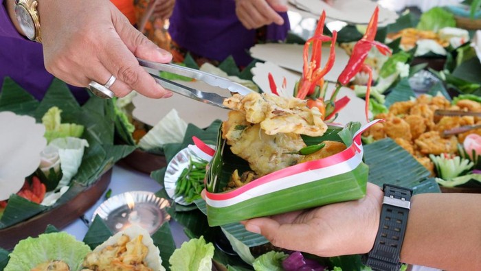 Peserta membagikan makanan yang diolah dari bahan pangan lokal kepada warga saat Festival Pangan dan Cipta Menu Bergizi di Desa Sumerta Kelod, Denpasar, Bali, Kamis (14/8/2025). Festival yang digelar dalam rangka memperingati Hari Ulang Tahun ke-80 Kemerdekaan Republik Indonesia dan Hari Jadi ke-67 Provinsi Bali tersebut diikuti puluhan warga dengan nuansa merah putih yang bertujuan memperkuat ketahanan pangan dengan memberdayakan potensi lokal serta mengembangkan keterampilan warga khususnya di bidang kuliner guna kedepannya membuka peluang untuk berwirausaha. ANTARA FOTO/Nyoman Hendra Wibowo/bar