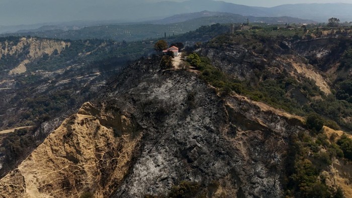 A drone view of a church amidst a burnt area following a wildfire in Kaminia, near Patras, Greece, August 13, 2025. REUTERS/Louiza Vradi