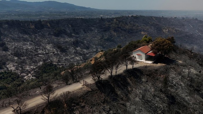 A drone view of a church amidst a burnt area following a wildfire in Kaminia, near Patras, Greece, August 13, 2025. REUTERS/Louiza Vradi