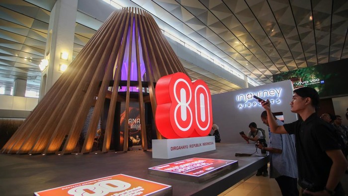 Calon penumpang mengamati karya seni produk nusantara  dalam ruang instalasi arsitektural Nusantara Heritage bertajuk Tanah Api, Jejak Jiwa di Terminal 3 Bandara Soekarno-Hatta, Tangerang, Banten, Kamis (14/8/2025).  Instalasi setinggi delapan meter tersebut berbentuk kerucut yang terinspirasi dari rumah adat Wae Rebo di Nusa Tenggara Timur dengan menghadirkan beragam karya seni produk nusantara untuk menyambut Hari Ulang Tahun ke-80 Kemerdekaan Republik Indonesia. ANTARA FOTO/Muhammad Iqbal