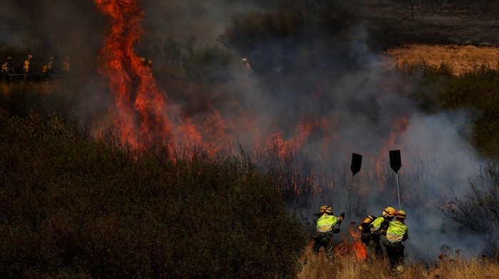 Firefighters work to extinguish a wildfire in the outskirts of Abejera de Tabara, Zamora, Spain, August 13, 2025. REUTERS/Susana Vera