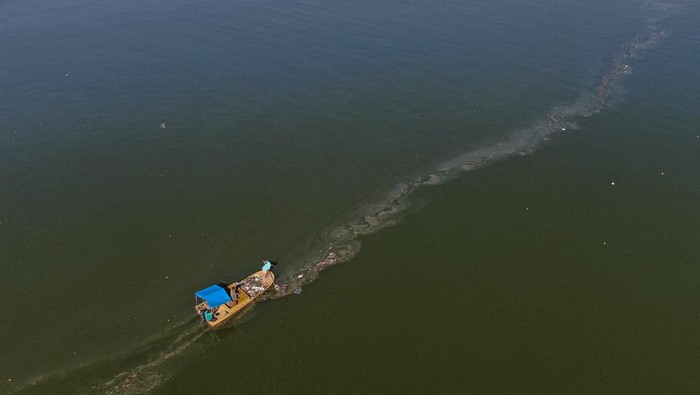 Petugas kebersihan DLHK Kendari memindahkan sampah dari atas perahu ke dalam penampungan di Teluk Kendari, Sulawesi Tenggara, Kamis (14/8/2025). Pemkot Kendari resmi mengeluarkan surat edaran bernomor 100.3.4.3/2614/Tahun 2025 tentang Penerapan Sanksi Membuang Sampah Sembarangan yaitu denda minimal Rp500 ribu dan maksimum Rp50 juta bagi masyarakat yang kedapatan buang sampah sembarangan guna mengurangi potensi pencemaran lingkungan di wilayah itu. ANTARA FOTO/Andry Denisah/nym.
