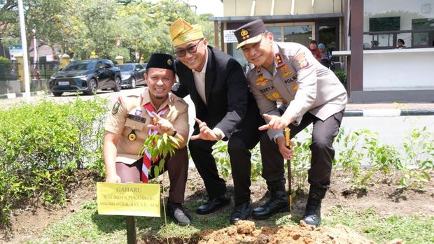 Kepala BKN Zudan Arif Fakrulloh dan Wali Kota Pekanbaru Agung Nugroho menanam pohon Gaharu di Mapolda Riau, Kamis (14/8/2025).