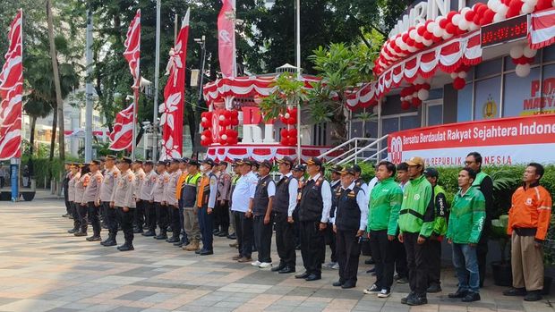 Polres Metro Jakpus mengibarkan Merah Putih dan mengumandangkan lagu Indonesia Raya di Bundaran HI, Jakarta.