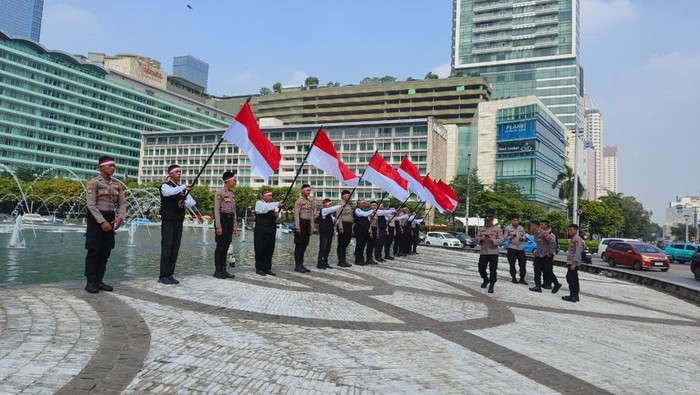 Polres Metro Jakpus mengibarkan Merah Putih dan mengumandangkan lagu Indonesia Raya di Bundaran HI, Jakarta.
