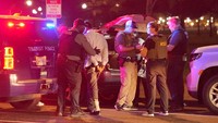 Petugas polisi memeriksa barang-barang milik seseorang yang ditahan karena masalah SIM, setelah pengumuman Presiden AS Donald Trump tentang pengambilalihan Departemen Kepolisian Metropolitan oleh pemerintah federal di bawah Undang-Undang Home Rule dan pengerahan Garda Nasional untuk membantu pencegahan kejahatan di ibu kota negara, dekat Gedung Putih, di Washington, D.C., AS, Rabu (13/8/2025). REUTERS/Ken Cedeno