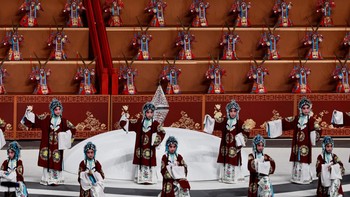 Penampil membawakan Opera Beijing di hadapan robot humanoid berbusana khas saat pembukaan World Humanoid Robot Games perdana di National Speed Skating Oval, Beijing, China, Kamis (14/8/2025). Ajang ini untuk pertama kalinya mempertemukan inovasi robot berbentuk manusia dari berbagai negara. REUTERS/Tingshu Wang  