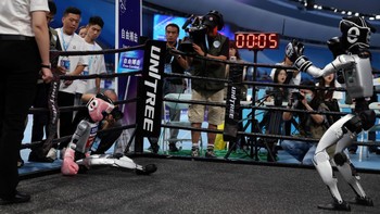 Robot humanoid Unitree Robotics saling menyerang dalam duel kickboxing di World Humanoid Robot Games perdana di National Speed Skating Oval, Beijing, China, Jumat (15/8/2025). Aksi mereka meniru pertarungan atlet profesional di atas ring. REUTERS/Tingshu Wang  