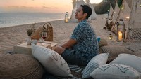 Momen menikmati wine juga terlihat pada foto ini. Kali ini ia menikmatinya di Canna Bali, sebuah beach club yang populer di Bali. Foto: Instagram/@kennyauztin