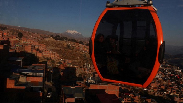 People ride in a cable car system named Mi Teleferico, ahead of Bolivia's general election to be held on August 17, in El Alto, Bolivia August 14, 2025. REUTERS/Pilar Olivares     TPX IMAGES OF THE DAY REFILE - CORRECTING FROM 