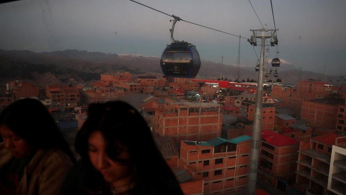 People ride in a cable car system named Mi Teleferico, ahead of Bolivia's general election to be held on August 17, in El Alto, Bolivia August 14, 2025. REUTERS/Pilar Olivares TPX IMAGES OF THE DAY REFILE - CORRECTING FROM 
