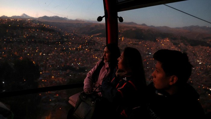 People ride in a cable car system named Mi Teleferico, ahead of Bolivia's general election to be held on August 17, in El Alto, Bolivia August 14, 2025. REUTERS/Pilar Olivares TPX IMAGES OF THE DAY REFILE - CORRECTING FROM 
