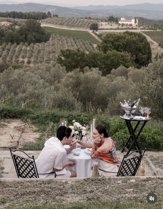 Luna tampil anggun dengan atasan putih berpotongan simpel, dipadukan dengan kain warna keemasan yang mewah. Ia melengkapi gayanya dengan scarf bermotif oranye yang memberi sentuhan segar pada tampilannya. Foto: Instagram/@lunamaya