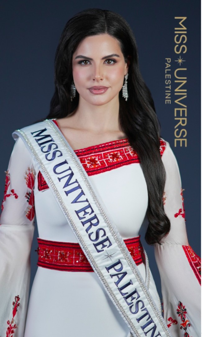 Dalam postingan pengenalannya sebagai finalis, Nadeen terlihat cantik mengenakan baju tradisional bersulam tatreez dari desaier Hiba Abdelkarim. Penampilannya dilengkapi dengan tatanan rambut ikal, makeup flawless, dan drop earring yang menambah kesan glamour. Foto: Instagram @nadeen.m.ayoub