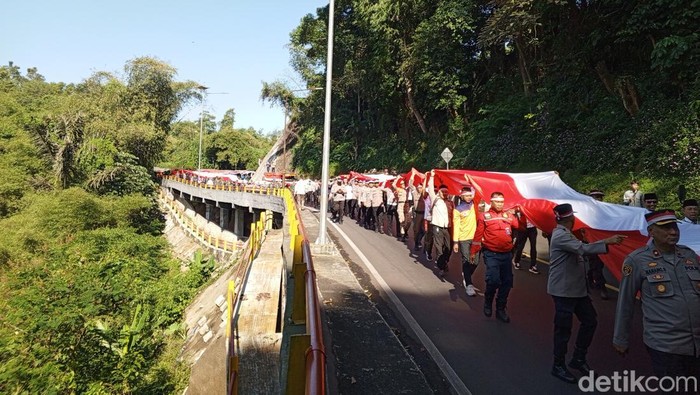 Petugas membentangkan bendera merah putih raksasa di Cadas Pangeran